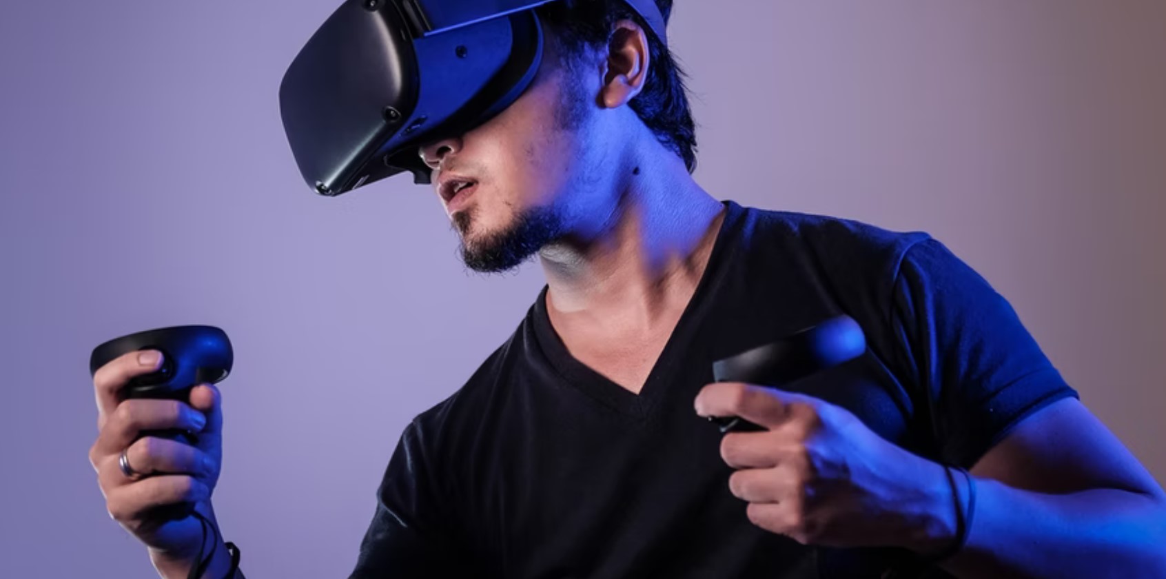 Man wearing VR headset and holding two controllers