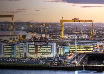 Evening view across Belfast, with Shipyard cranes in foreground and Mourne Mountains in distance