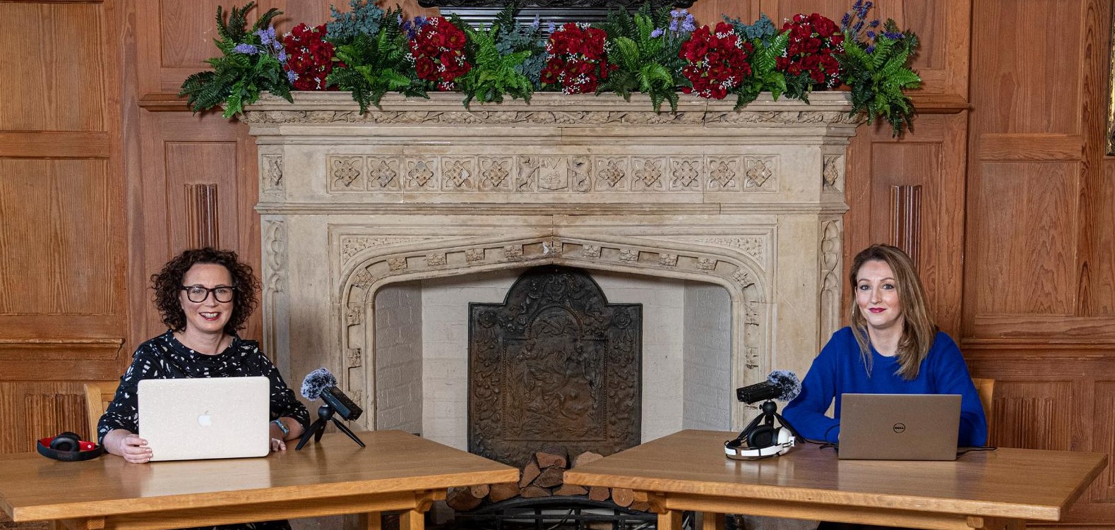 Dr Leanne McCormick (left) and Dr Elaine Farrell (right) seated in front of grand fireplace in the Great Hall at Queen's