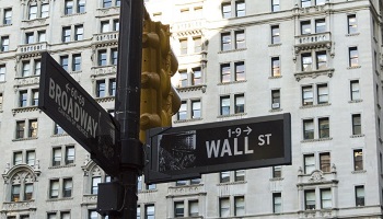 Wall St signpost, showing also Broadway and yellow traffic lights