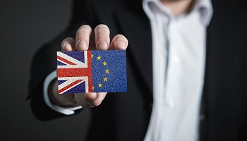 Male hand holding credit card shaped image of UK and EU flags (50/50) to represent UK Brexit