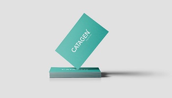 Pointed end of teal coloured CATAGEN business card balances on stack of business cards