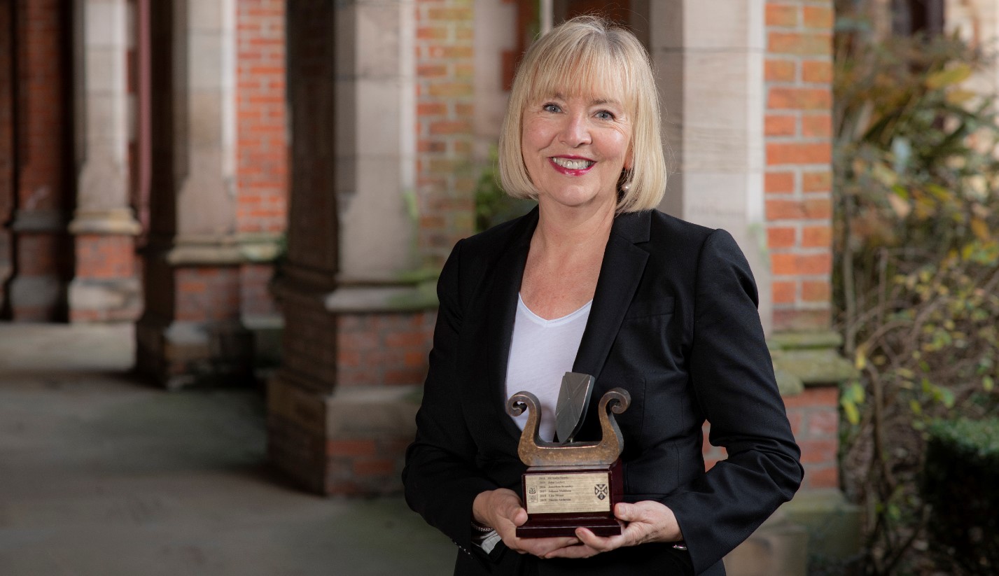 Marie-Thérèse McGivern, Queen's Graduate of the Year 2020, holding trophy, pictured in cloisters at University
