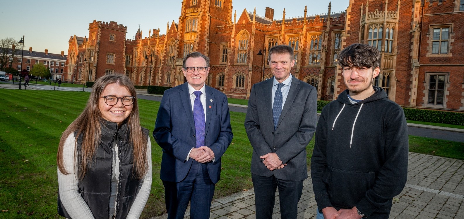 Group of four people, including the Vice-Chancellor, in front of Queen's