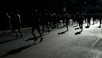 Mono image of multiple runners on city street