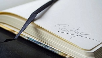 Open book with ribbon marker lying across page and the word 'poetry' written at bottom of an otherwise blank right hand page