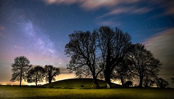 Navan Fort with starry night sky and dark trees