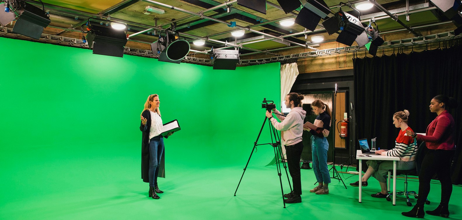 Five young student film makers rehearsing against green screen