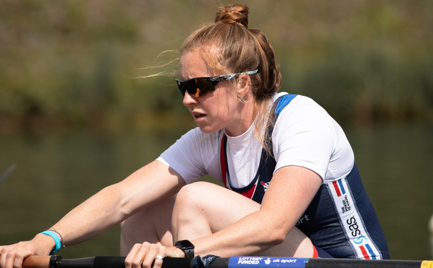 Olympic rower, Rebecca Edwards, in side on pose in rowing boat on river, wearing shades