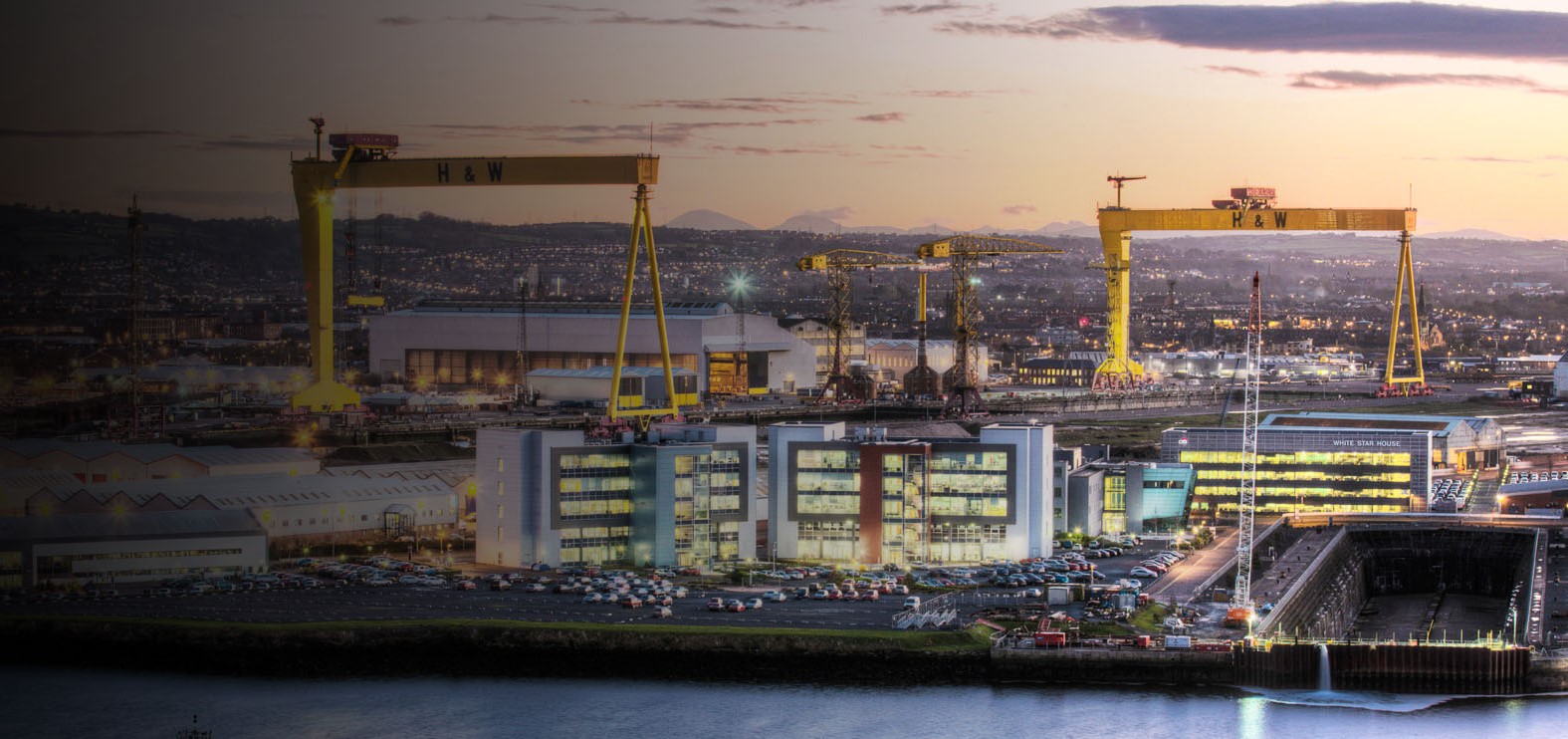 Aerial view of Belfast with Samson and Goliath cranes and shipyard in foreground and Mourne Mountains in distance