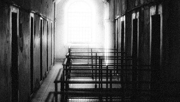 Black and white image of prison floor, light streaming through window