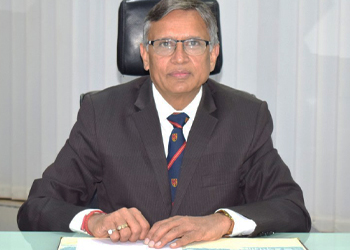 Dr Sandeep sits at his desk